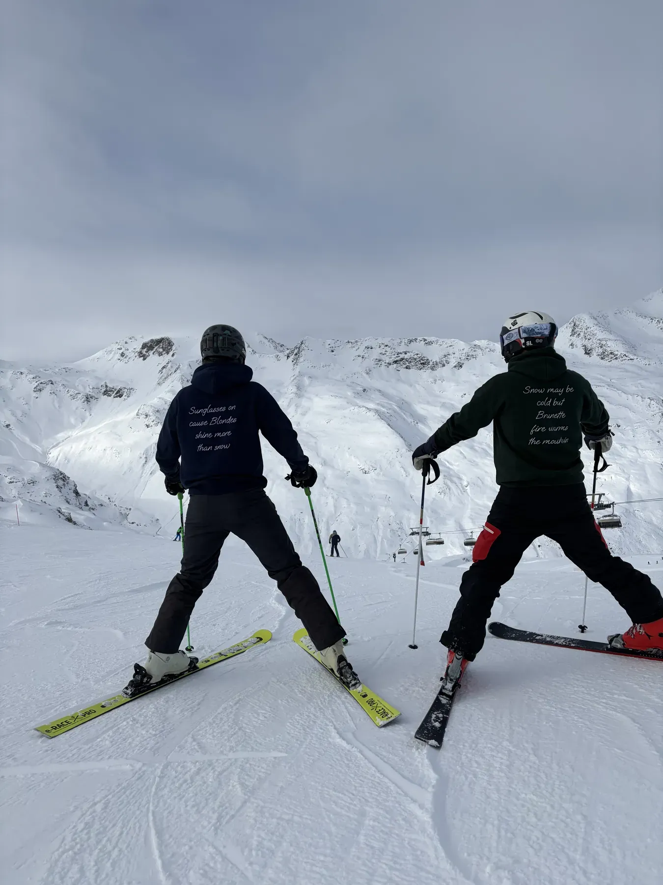 Due sciatori di spalle guardano la valle innevata